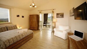 A bedroom with a bed, a desk with a laptop, a chair, a wardrobe, and a view of the outdoors. - Pietriccio Rosso (Manciano)