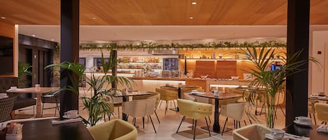 Un restaurante moderno con techo de madera, varias mesas y sillas.