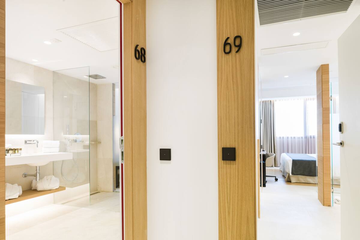 Una habitación de hotel moderna con baño, cama y escritorio.