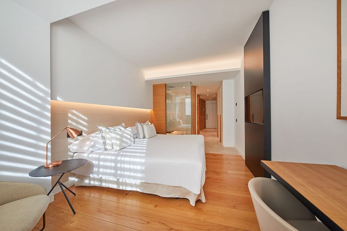 Een moderne hotelkamer met een groot bed, een bureau en een televisie.