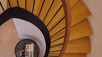Una escalera de caracol con escalones de madera y barandilla negra.