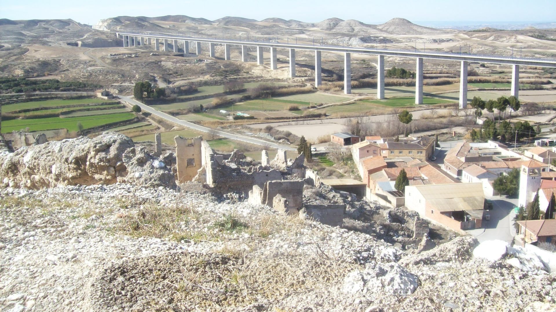 Un puente sobre un valle con un complejo de edificios históricos en primer plano.