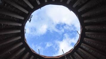 A circular window with a view of the sky through a structure with vertical beams.
