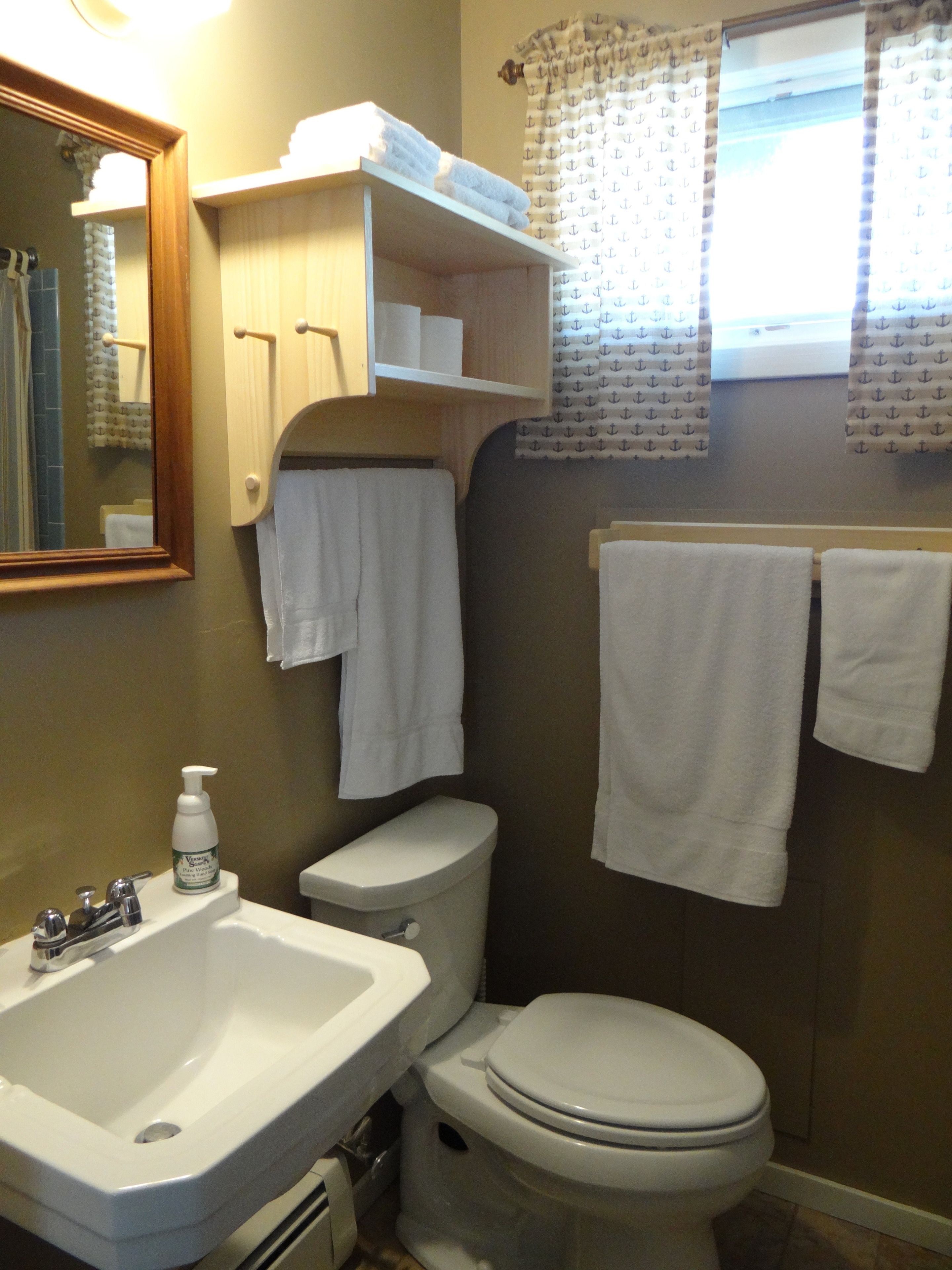 A bathroom with a sink, toilet, and towel rack.