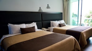 A hotel room with two beds, a dark headboard, and a large window with a view of palm trees. - Hotel Posada Señorial (San Andrés Cholula)