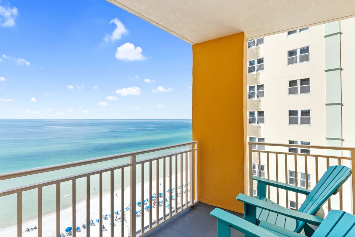 A balcony with a view of the beach and ocean.