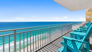 A balcony with a view of the ocean, turquoise chairs, and a building with balconies. - Splash Beach Resort by Panhandle Getaways (Panama City Beach)