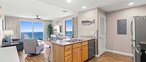 A modern kitchen with wooden cabinets, a built-in dishwasher, and a large island with a sink.