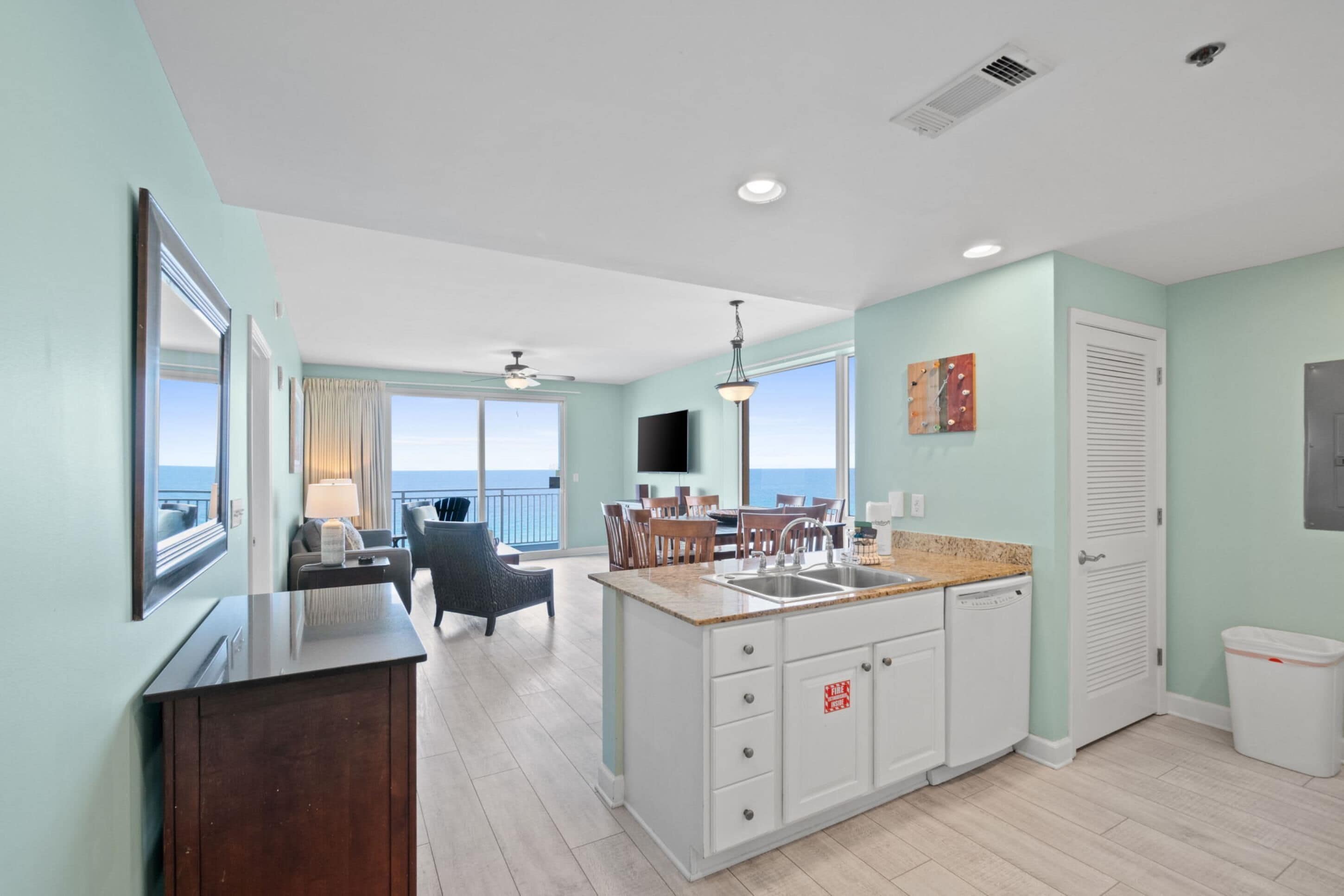 A modern kitchen with a large island, a dining area with a view, and a balcony with a view.