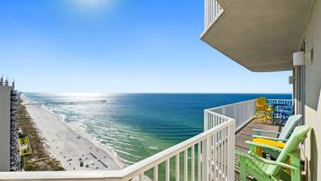 A balcony with a view of a beach and a pier.