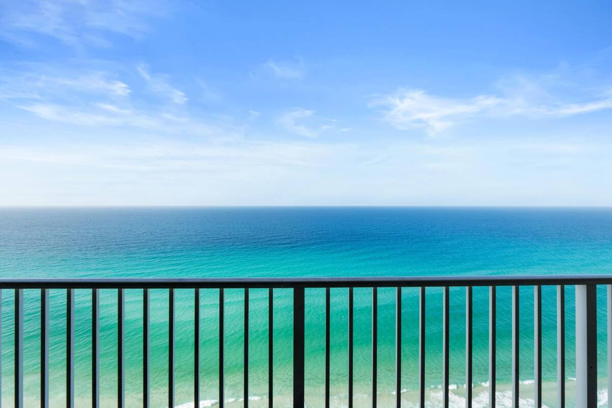 Un balcon avec vue sur l’océan et un ciel dégagé.