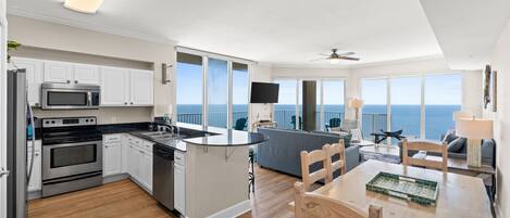 A modern kitchen with white cabinets, stainless steel appliances, and a large island.
