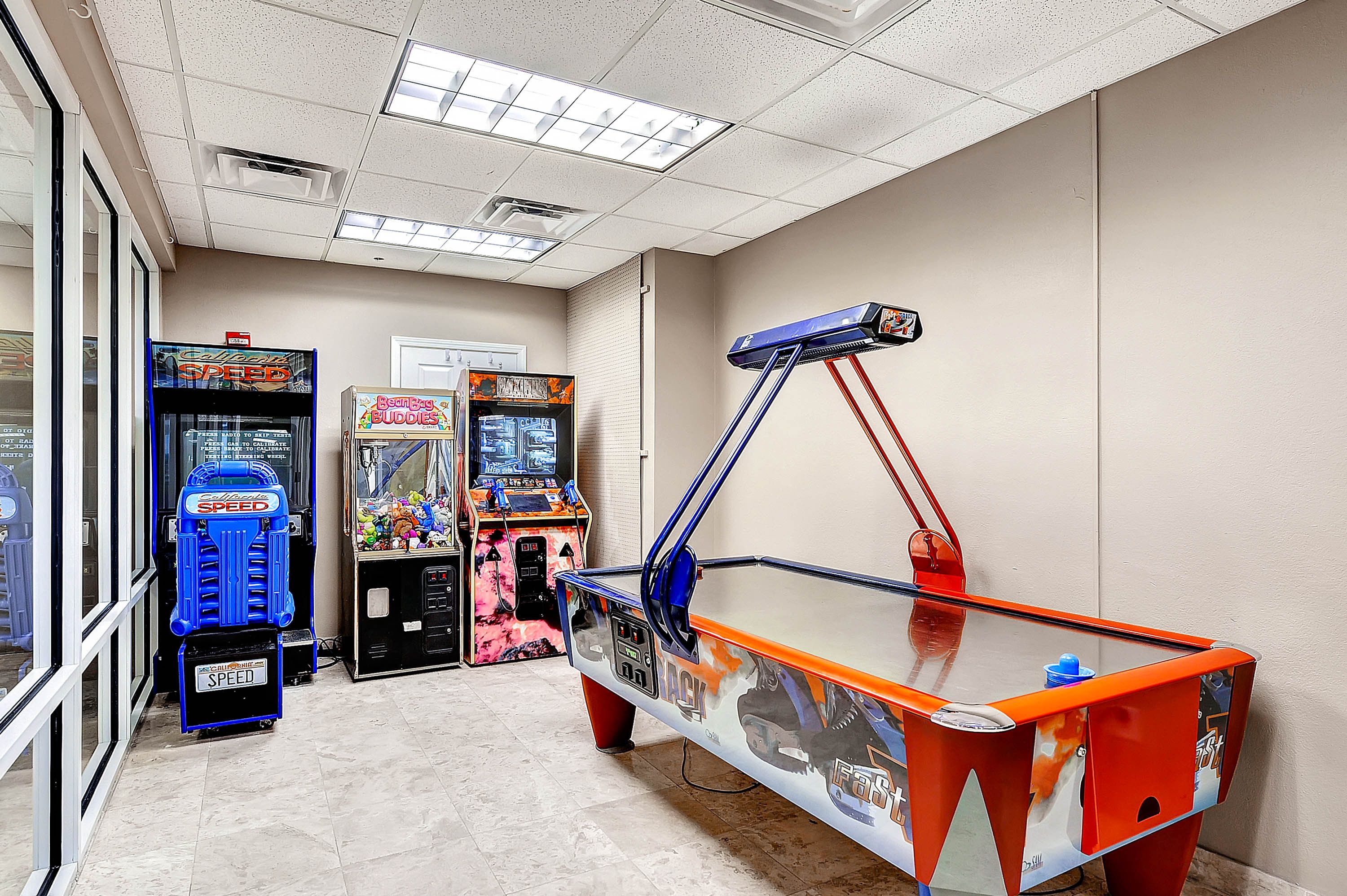 A room with arcade games, including a 'Speed' game, and a table with a 'Fast' theme.