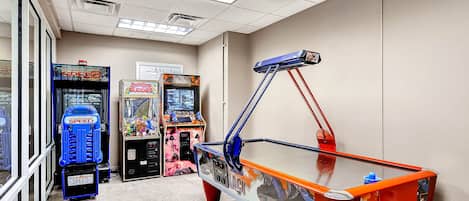 A room with arcade games, including a 'Speed' game, and a table with a 'Fast' theme.