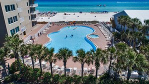 Une piscine entourée de palmiers et une plage.