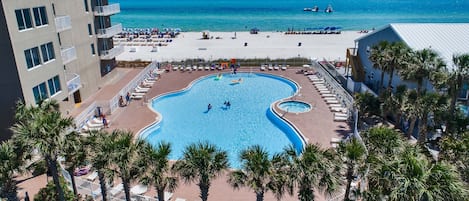 A pool surrounded by palm trees and a beach.