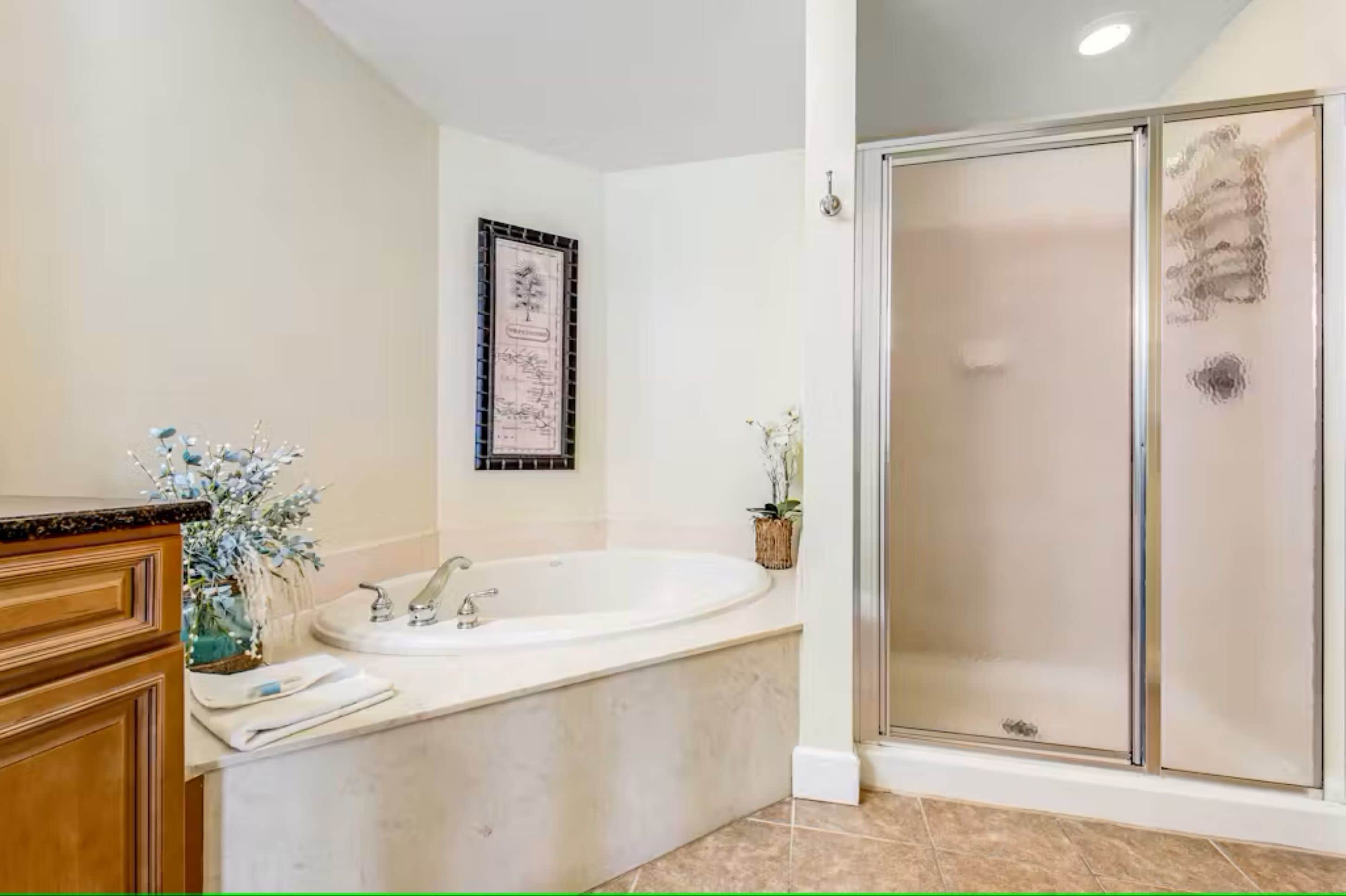 Une salle de bain avec une baignoire, une douche et un meuble-lavabo en bois.