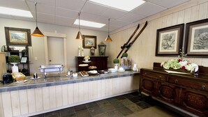 Un espace d’accueil avec un comptoir, des tableaux encadrés et un meuble en bois.