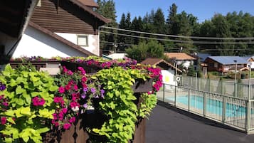 Relax by the serene pool surrounded by lush flowers and scenic views.