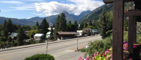 A mountain town with a clear road, buildings, and a view of the mountains.