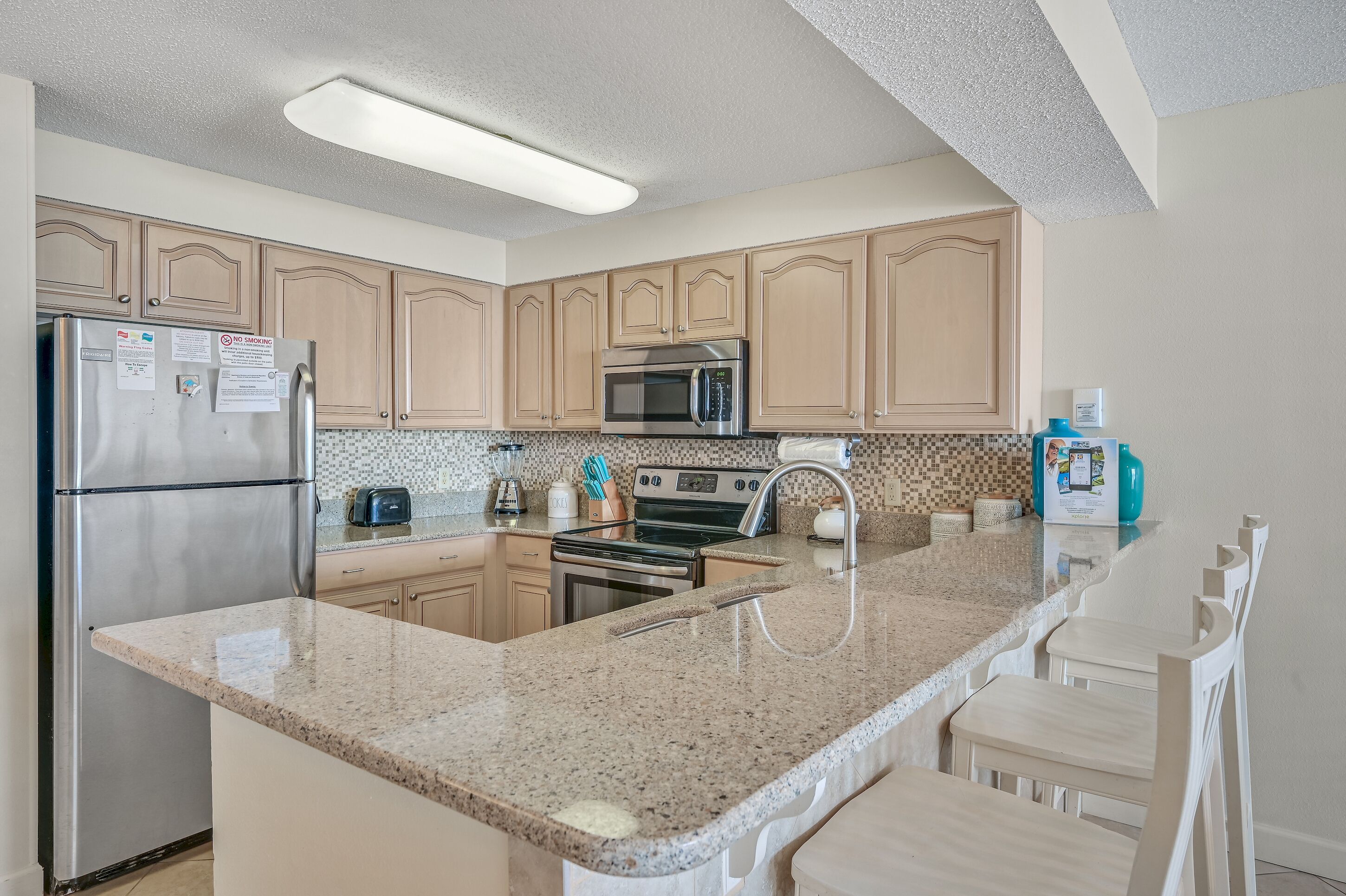 A kitchen with granite countertops, stainless steel appliances, and wooden cabinets.