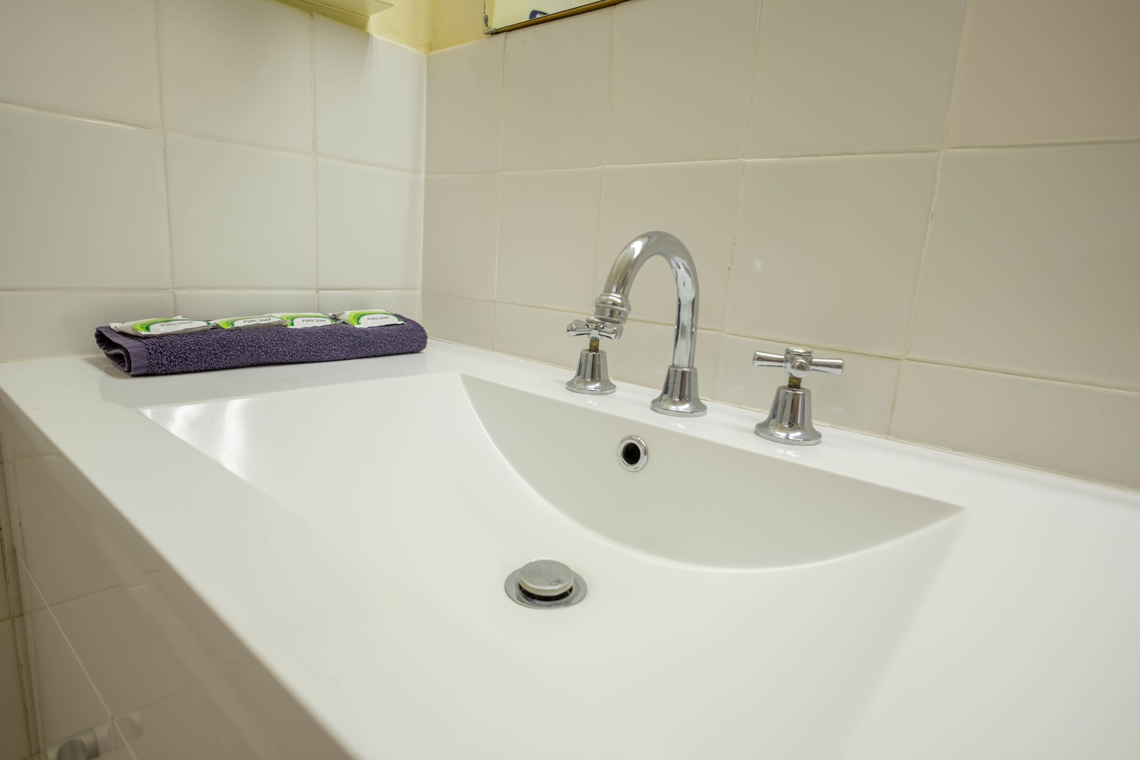 Eine weiße Badewanne mit einem Wasserhahn und einem Ablauf.