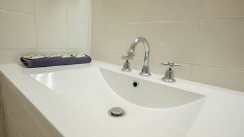 Une baignoire blanche avec un seul robinet et un drain.