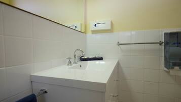A bathroom with a white sink, a mirror, and a towel rack.