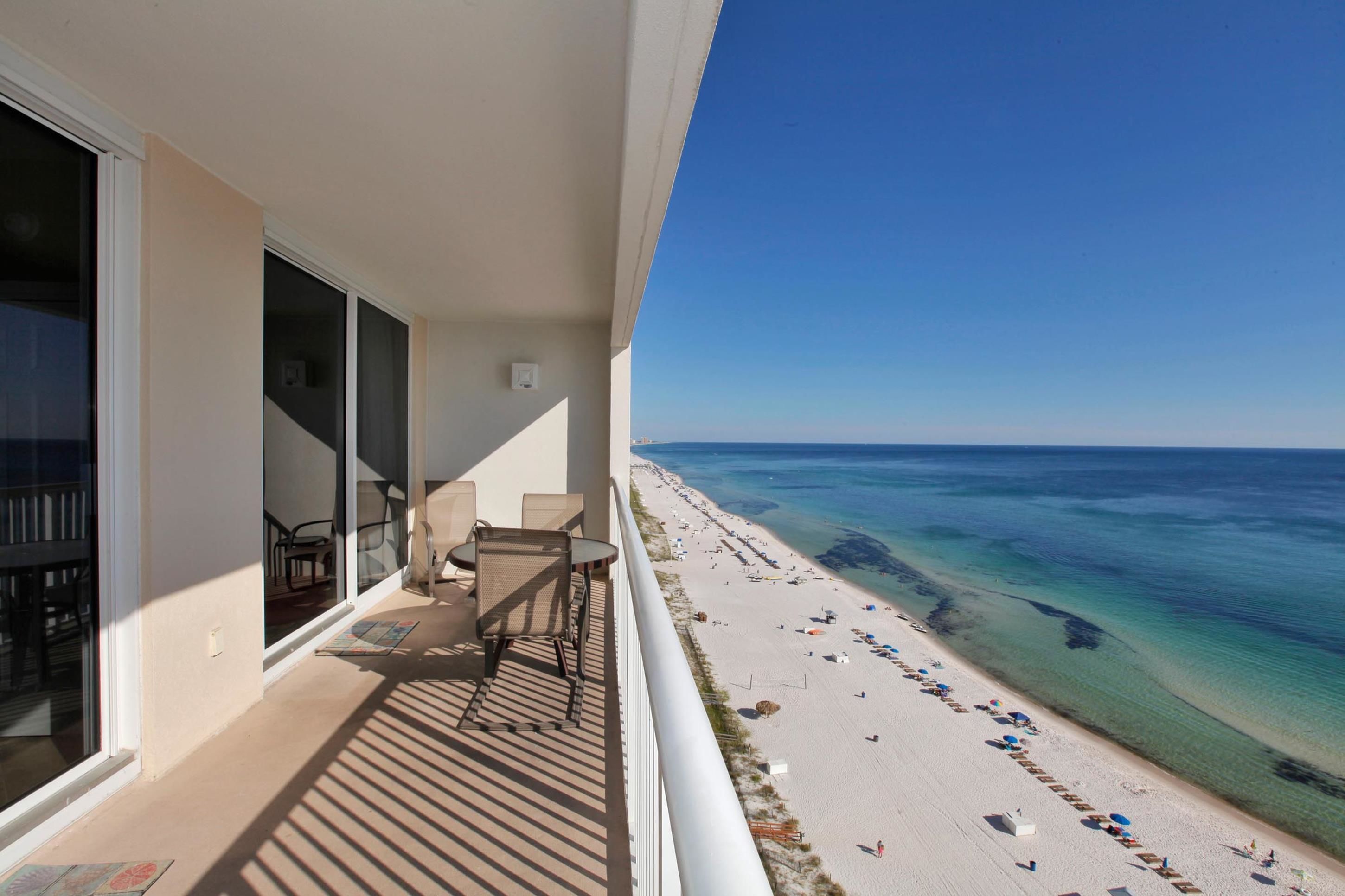 A balcony with a view of a beach and ocean.