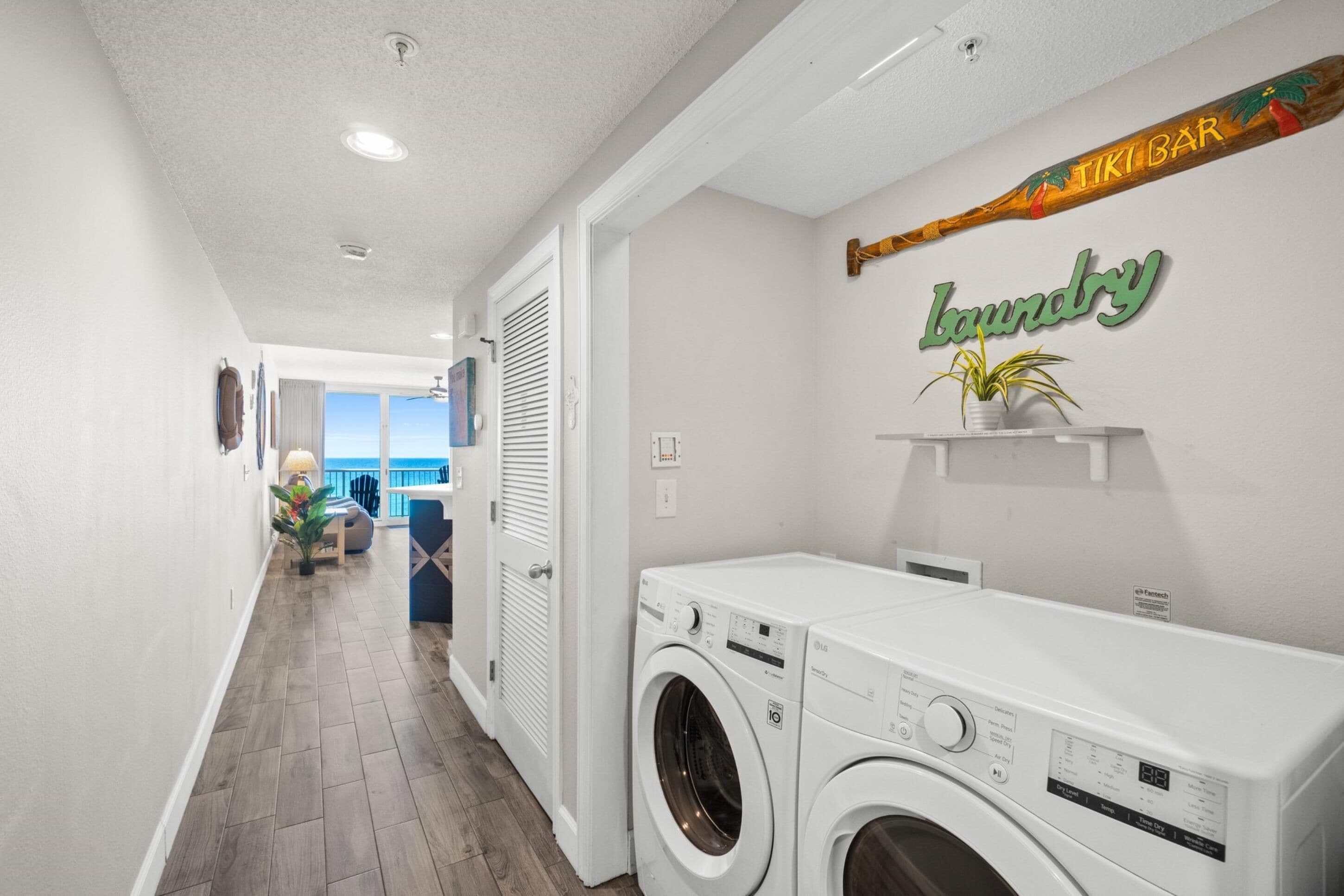 A laundry area with a washing machine, a shelf with a plant, and a sign that says "laundry".