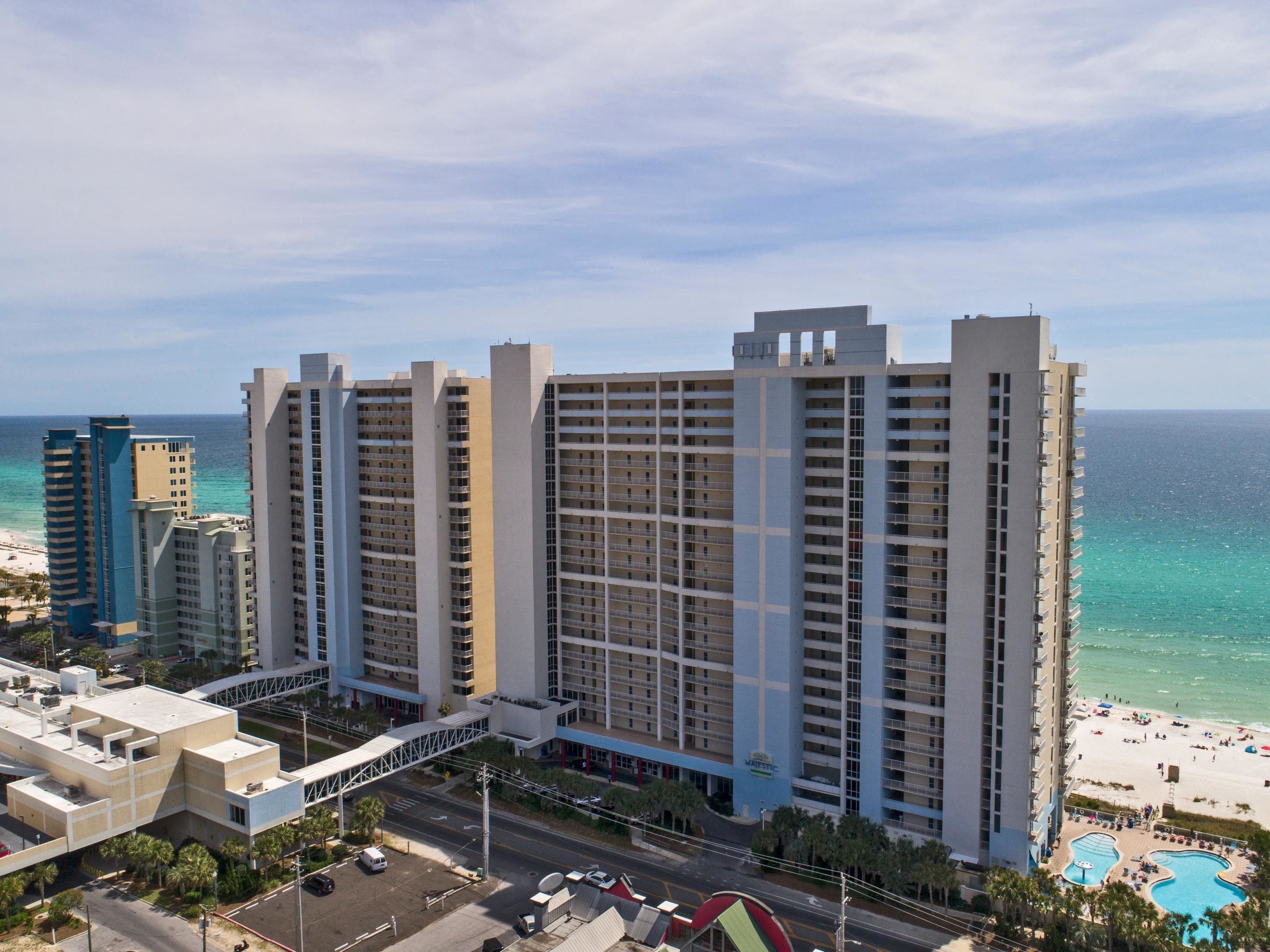 Un hotel moderno con numerosi piani, vista sulla spiaggia e area piscina.