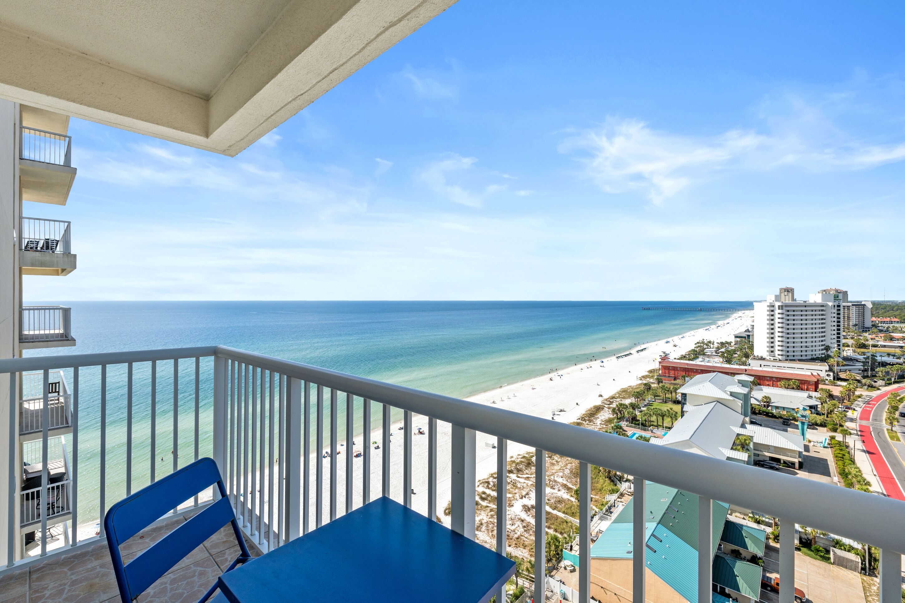 A balcony with a view of the beach and ocean.