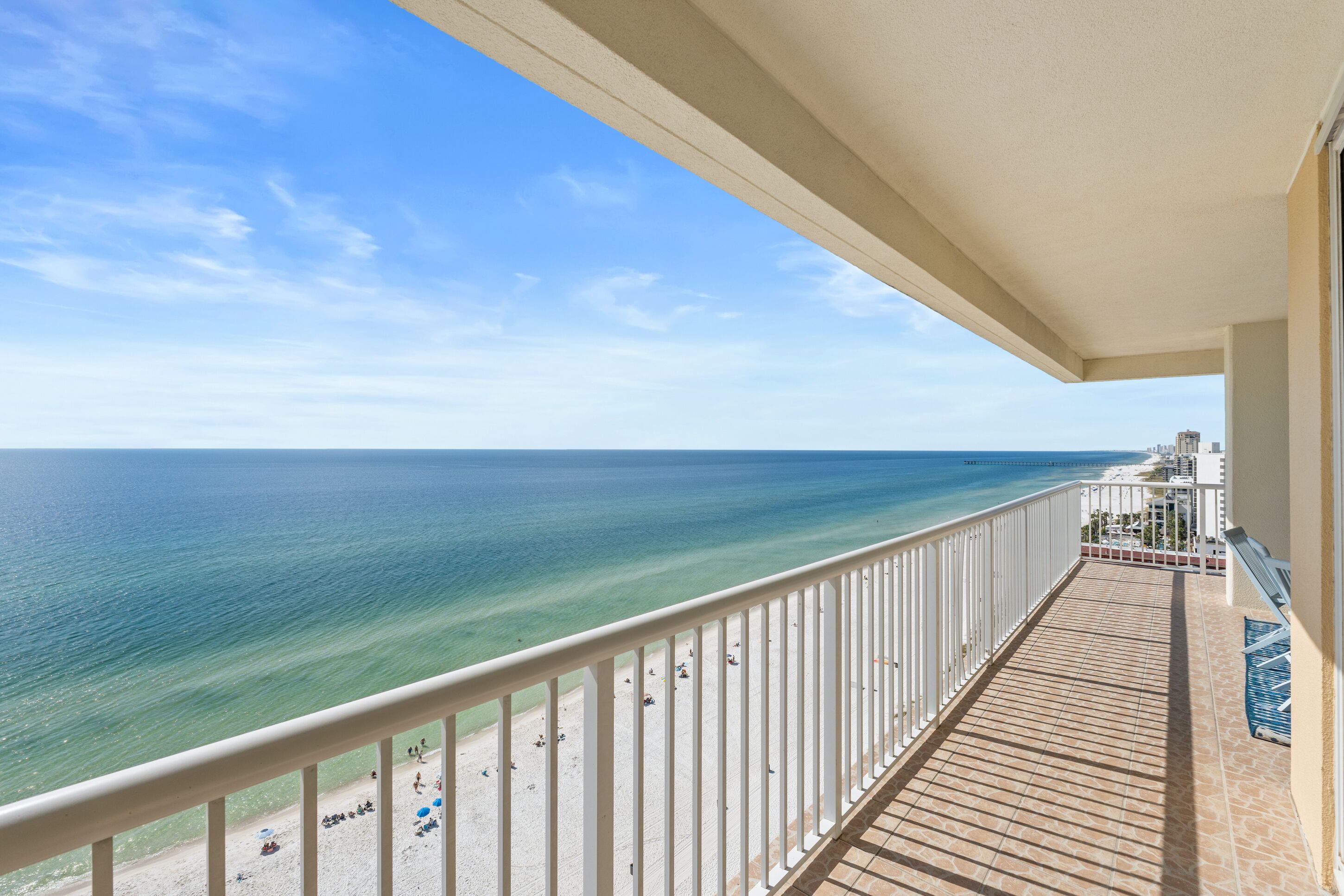 A balcony with a view of the ocean and beach.