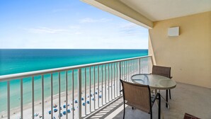 A balcony with a view of the ocean, a table, and chairs. - Majestic Beach Resort by Panhandle Getaways (Panama City Beach)