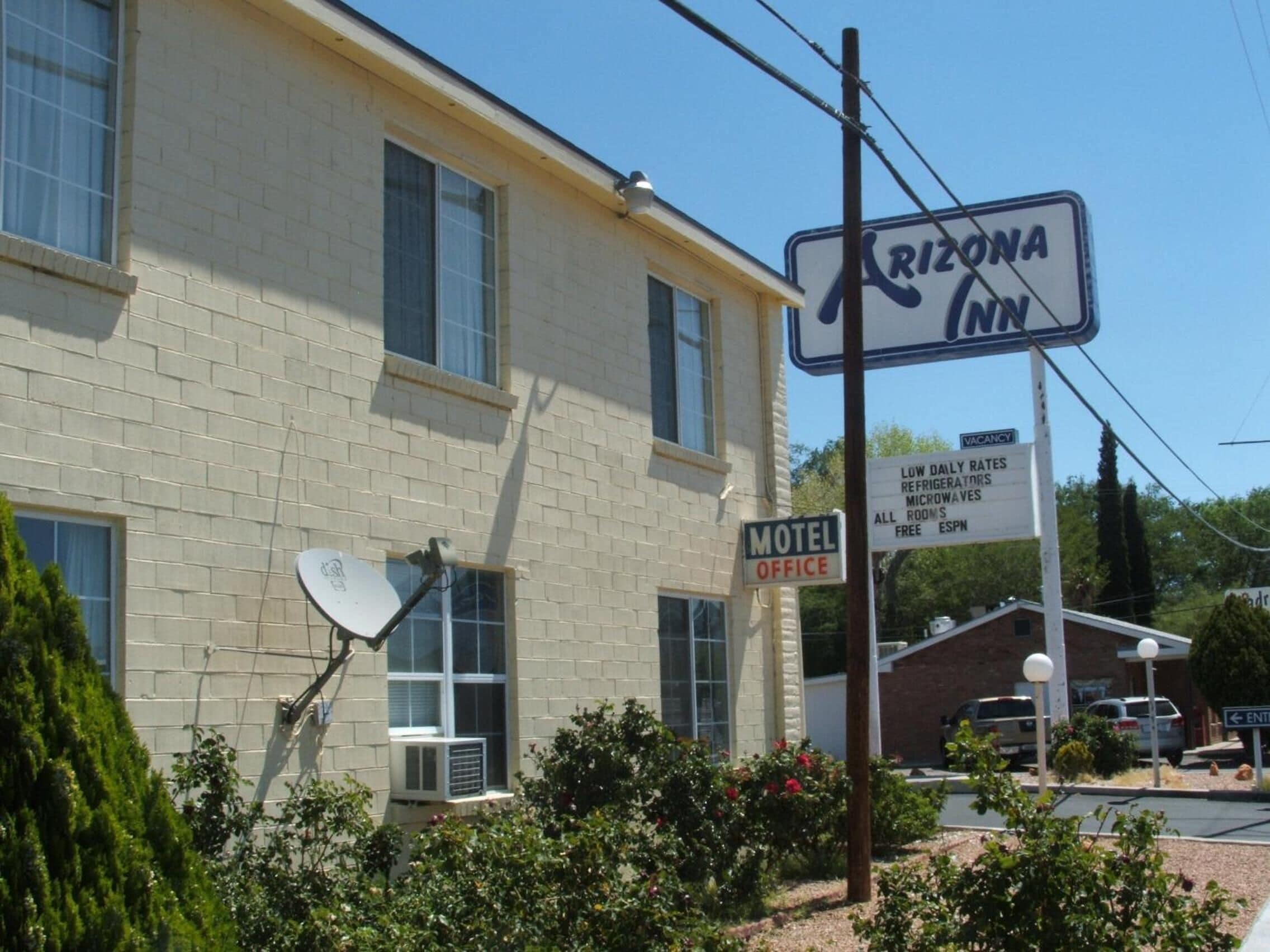 A motel office with a sign indicating low daily rates for refrigerators, microwaves, and all rooms are free.