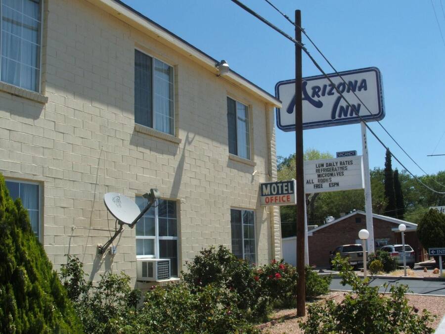 A motel office with a sign indicating low daily rates for refrigerators, microwaves, and all rooms are free.