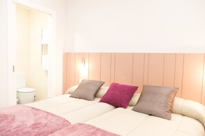 A double bed with two pillows, a bedside table, and a nightstand. - Linares Rooms Santiago (Santiago de Compostela)
