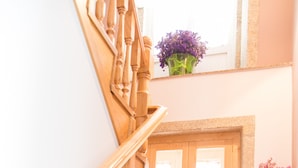 A wooden staircase with a handrail, leading to a door with a window above it. - Linares Rooms Santiago (Santiago de Compostela)