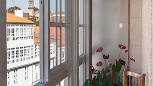 A room with a large window, a chair, and a potted plant. - Linares Rooms Santiago (Santiago de Compostela)
