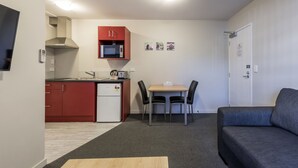 Un espacio habitable compacto con kitchenette, comedor y sofá.