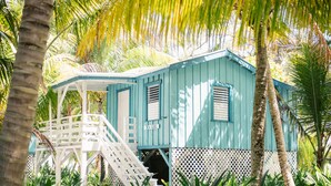 A small, single-story building with a white staircase leading to a covered porch. - Ranguana Caye Cabanas (Placencia)
