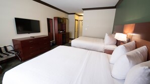 A hotel room with two beds, a TV, a desk, and a wardrobe.