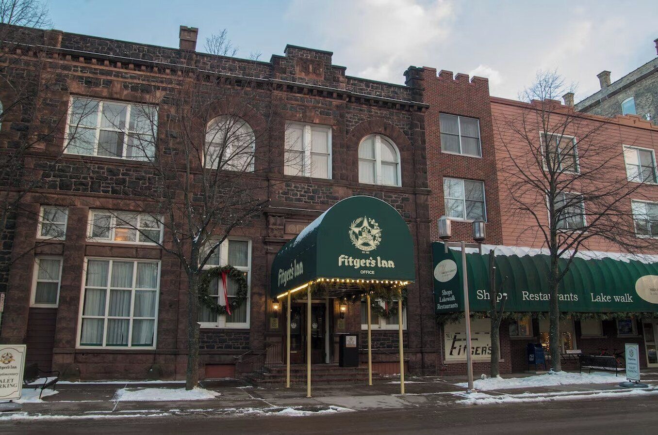 A brick building with a green awning labeled 'Fitzgeral's Inn Office.'