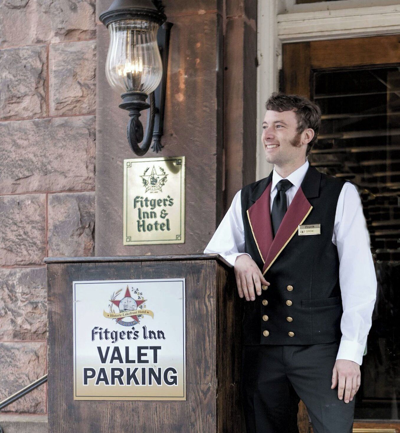 A hotel entrance with a sign for 'Fitter's Inn Valet Parking.'
