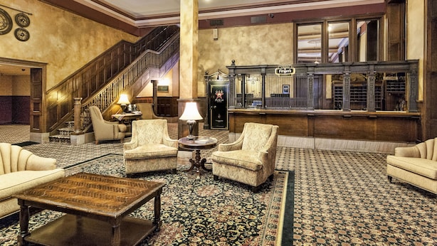 A lobby with a grand staircase, a reception desk, and seating areas. - Fitger's Inn (Duluth)