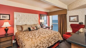 A hotel room with a large bed, a desk, a chair, and a view of the sea. - Fitger's Inn (Duluth)