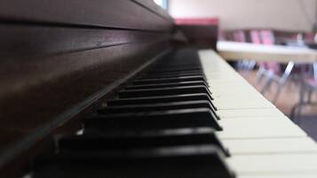 A piano with a dark wooden finish and white and black keys.