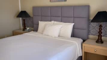 Una cama bien hecha con sábanas blancas en una habitación de hotel.