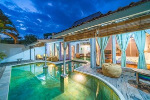 A pool area with a wooden deck, a bean bag chair, and a covered seating area with curtains. - Villa West (Seminyak)