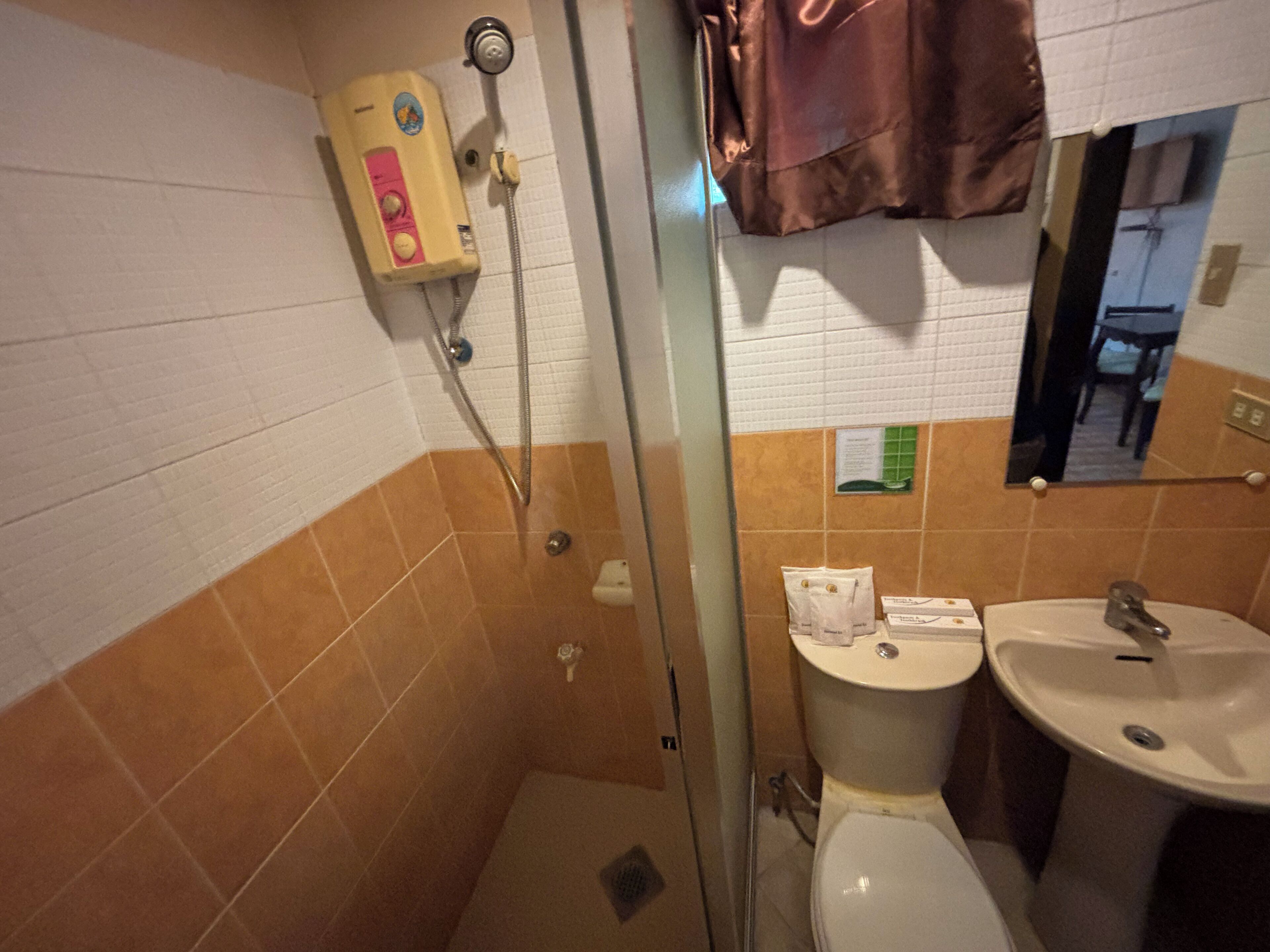 Une salle de bain avec une douche, des toilettes et un lavabo.